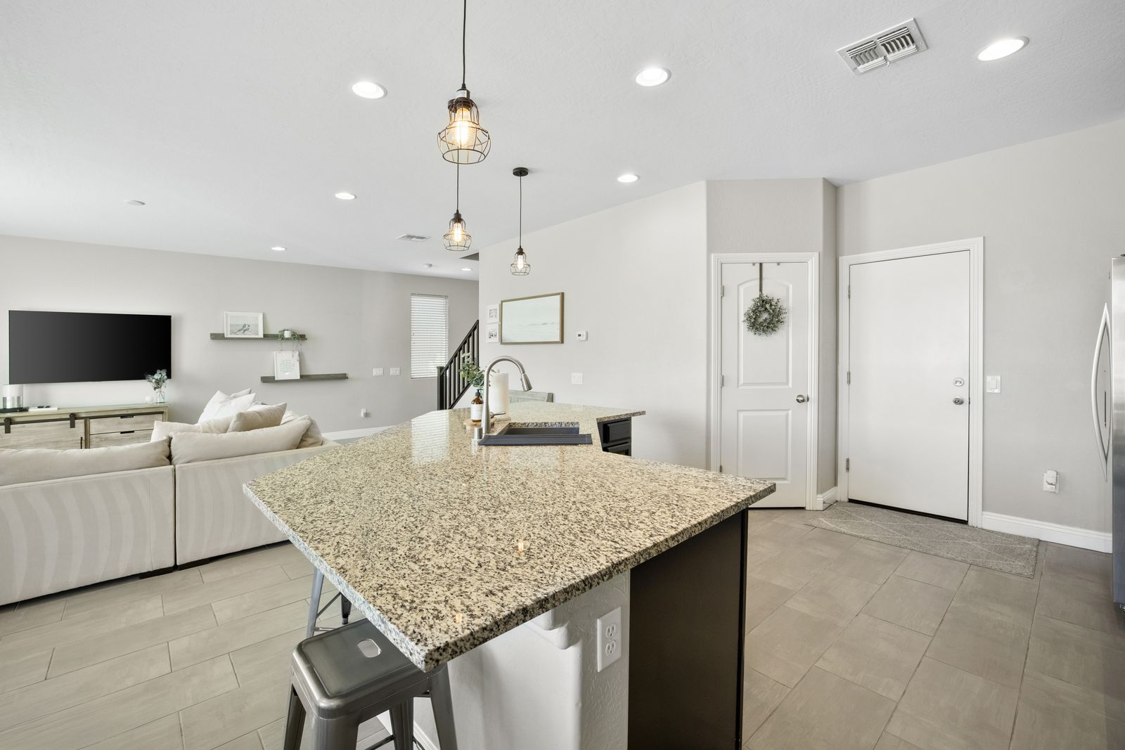 Granite island with breakfast bar seating and an undermount sink.