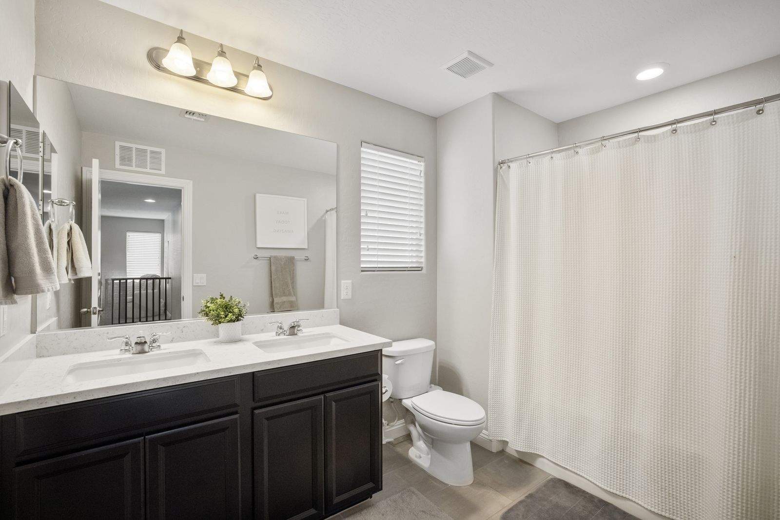 Hall bath. Double sinks and a tub shower combination.