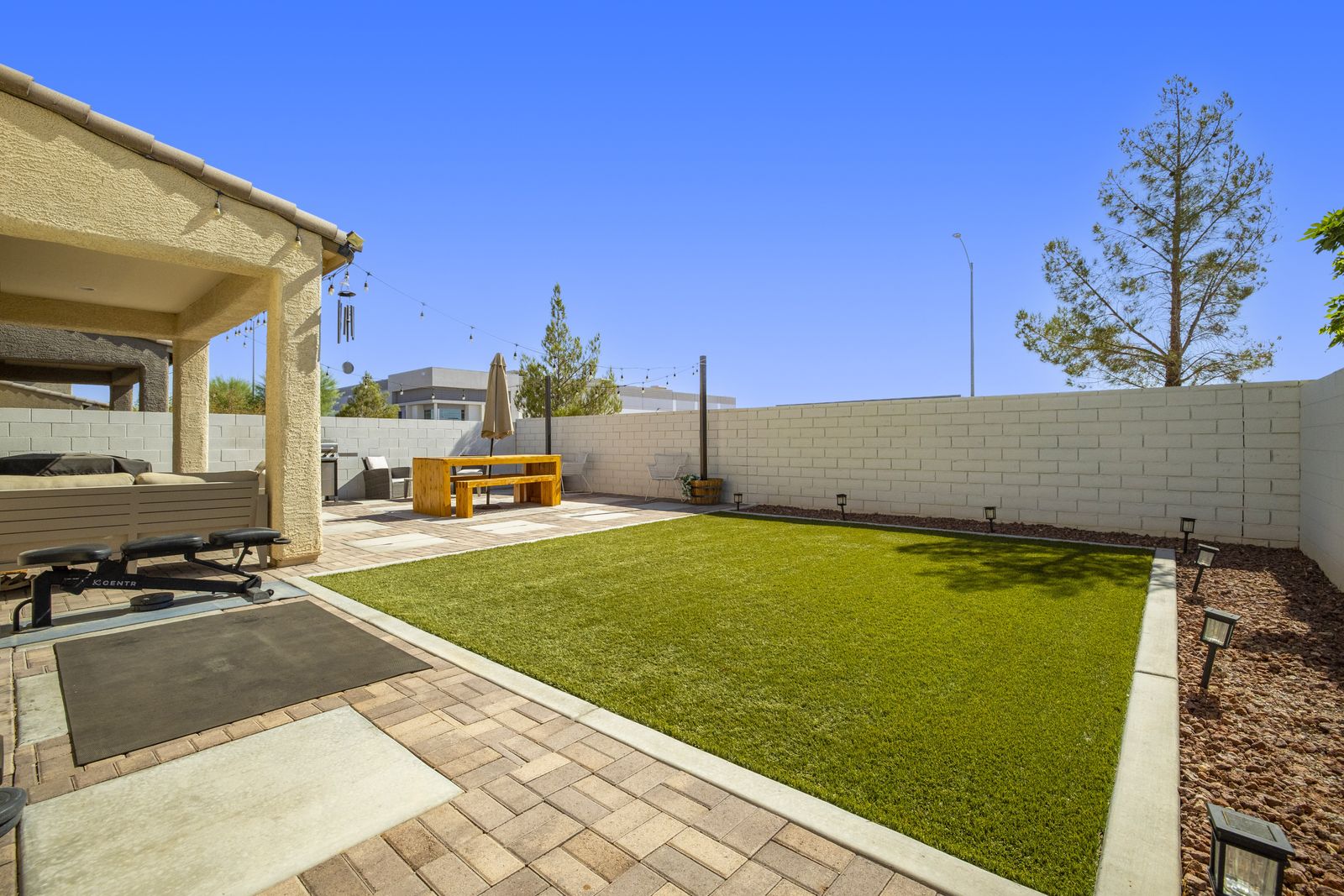 Artificial turf, paver patio, established trees.